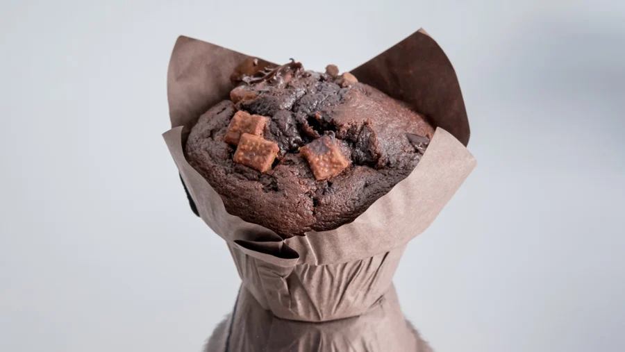 Muffin de chocolate en cápsula de papel sobre una superficie reflectante