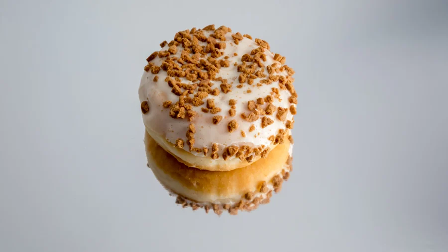 Bollo de cobertura blanca y galleta reflejado sobre fondo claro