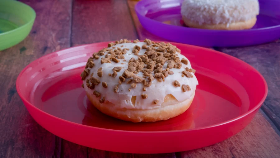 Bollo con cobertura blanca y galleta sobre un plato rojo