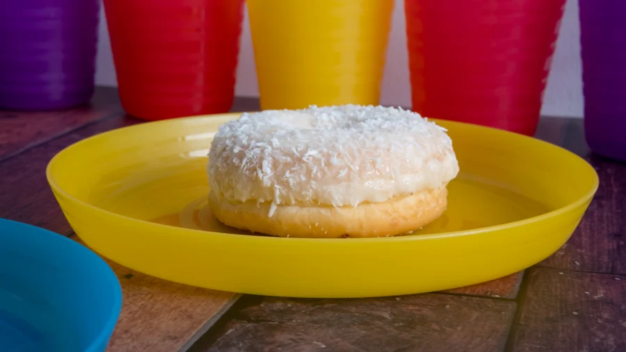 Rosquilla con cobertura de coco sobre un plato amarillo