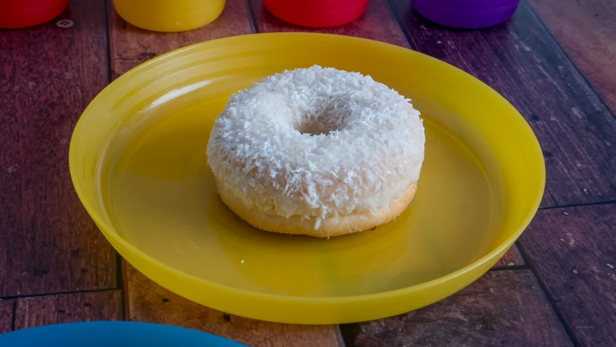Rosquilla de coco sobre plato amarillo vista desde arriba